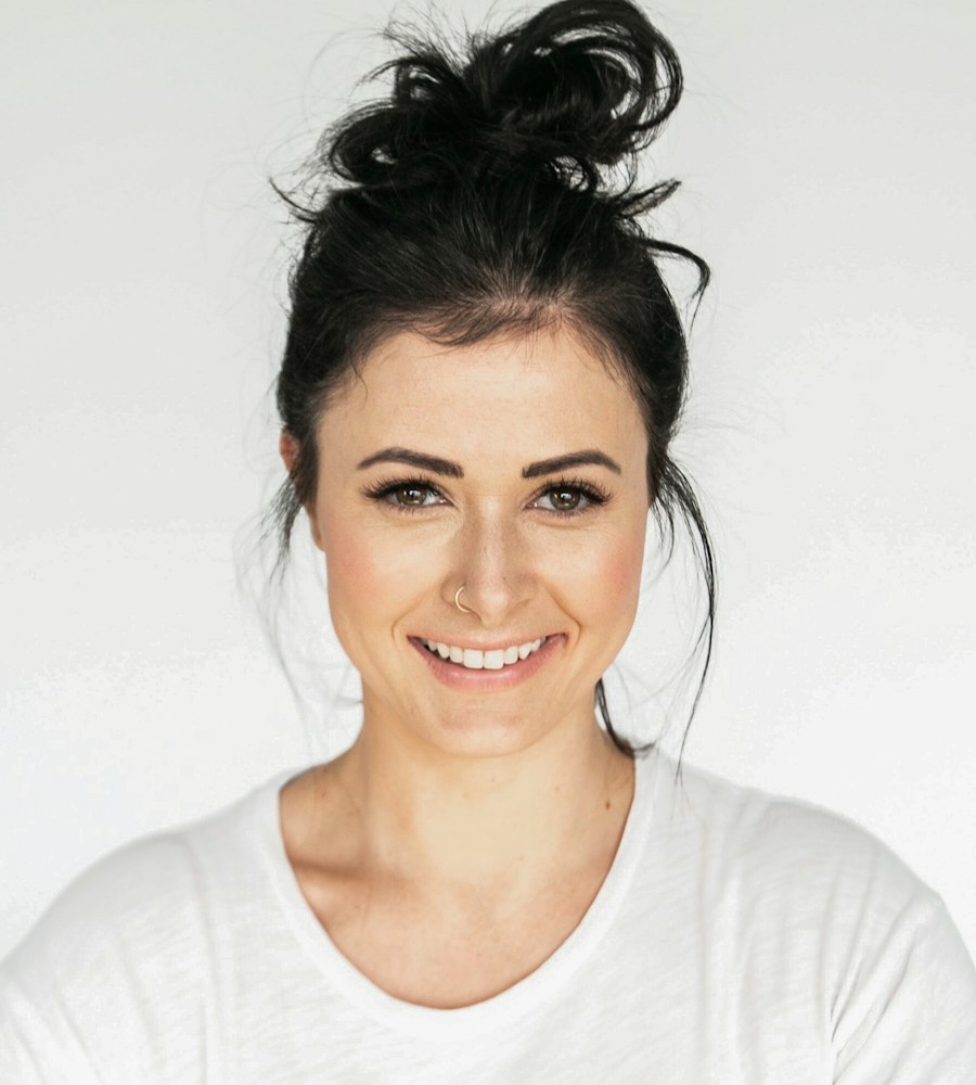 A smiling woman in a white top against a light background
